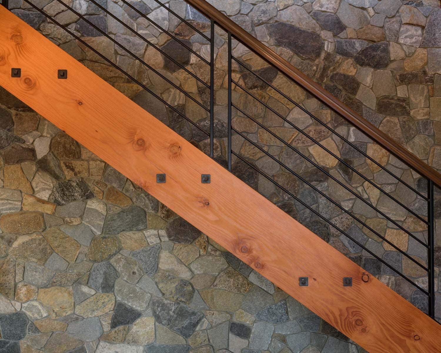 rustic staircase detail with a stone wall