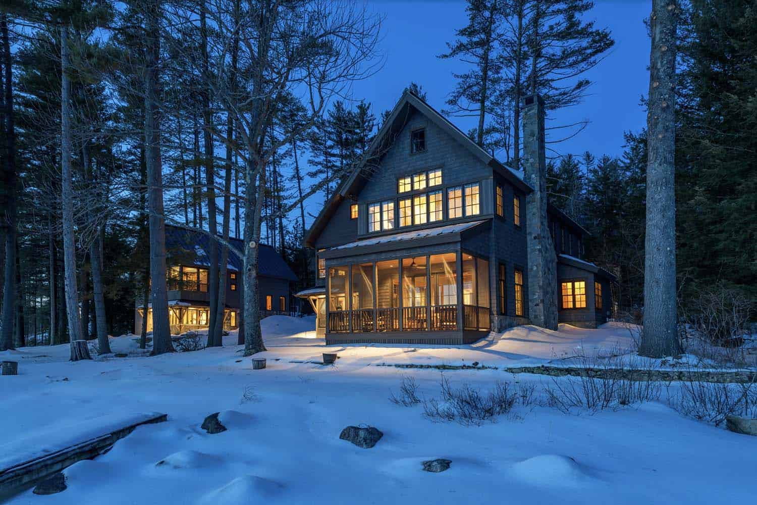 rustic lake house exterior at dusk with snow