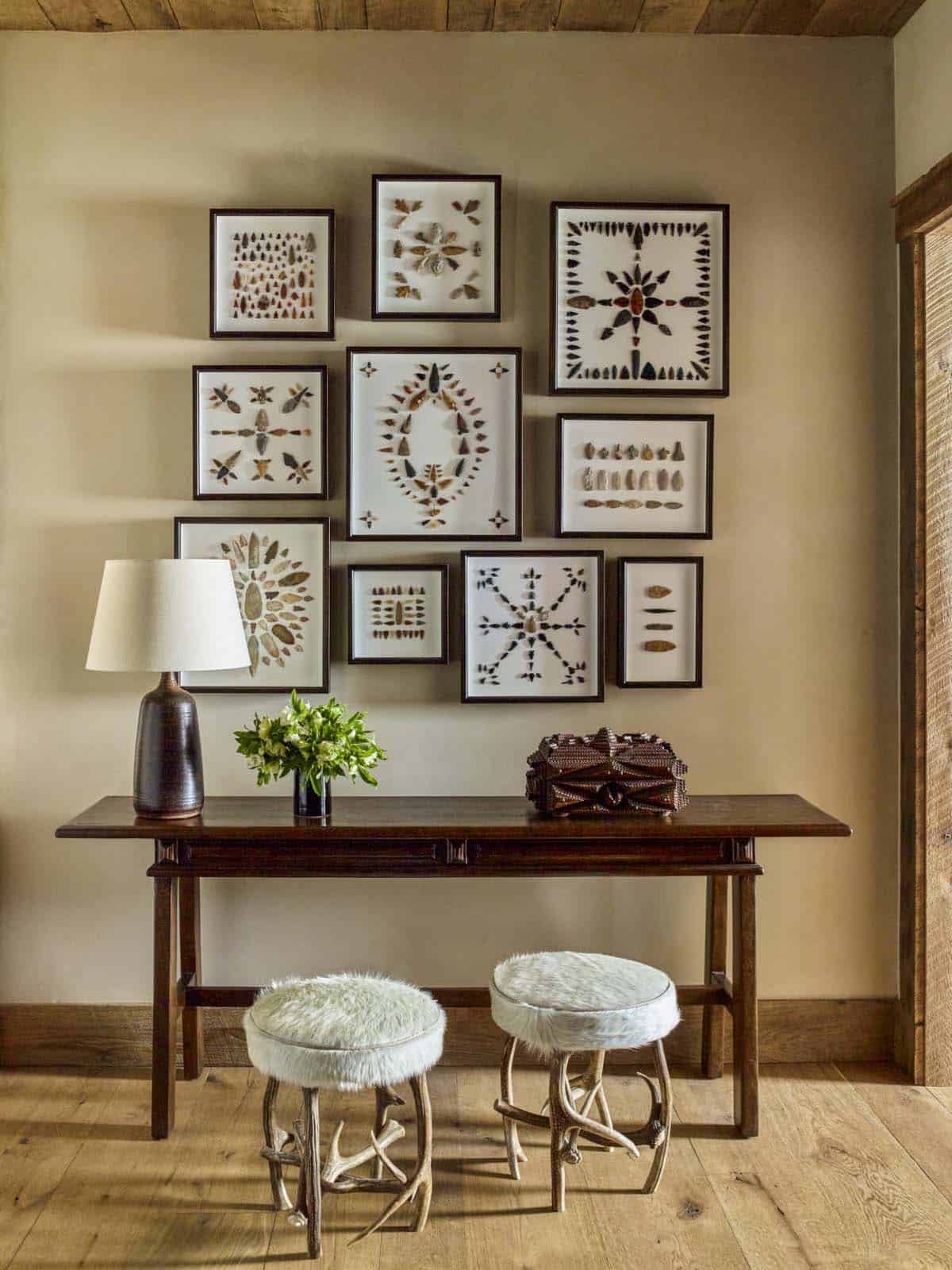 rustic console table with a pair of stools and artwork on the wall