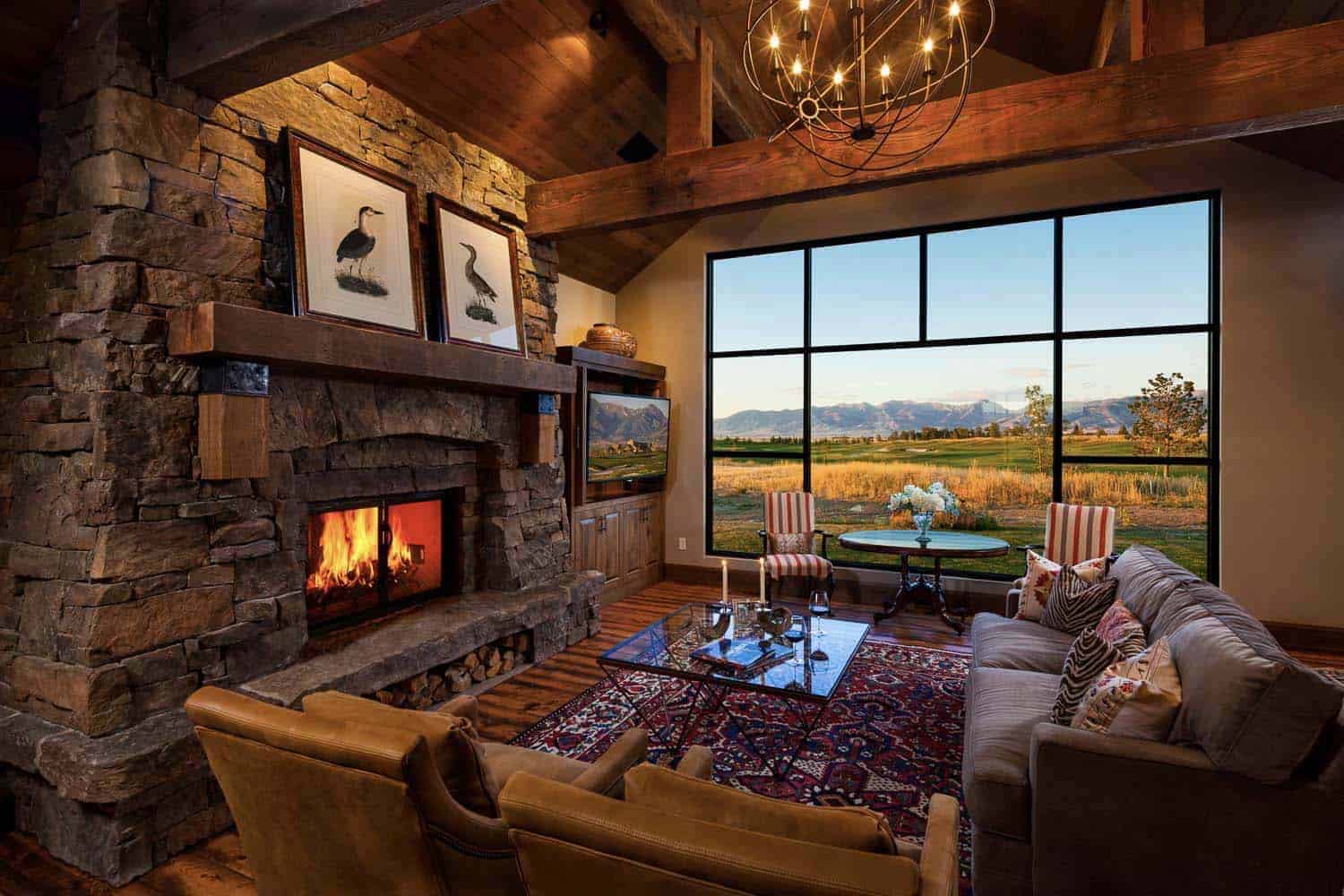 rustic living room with a fireplace and large window view of the mountains 
