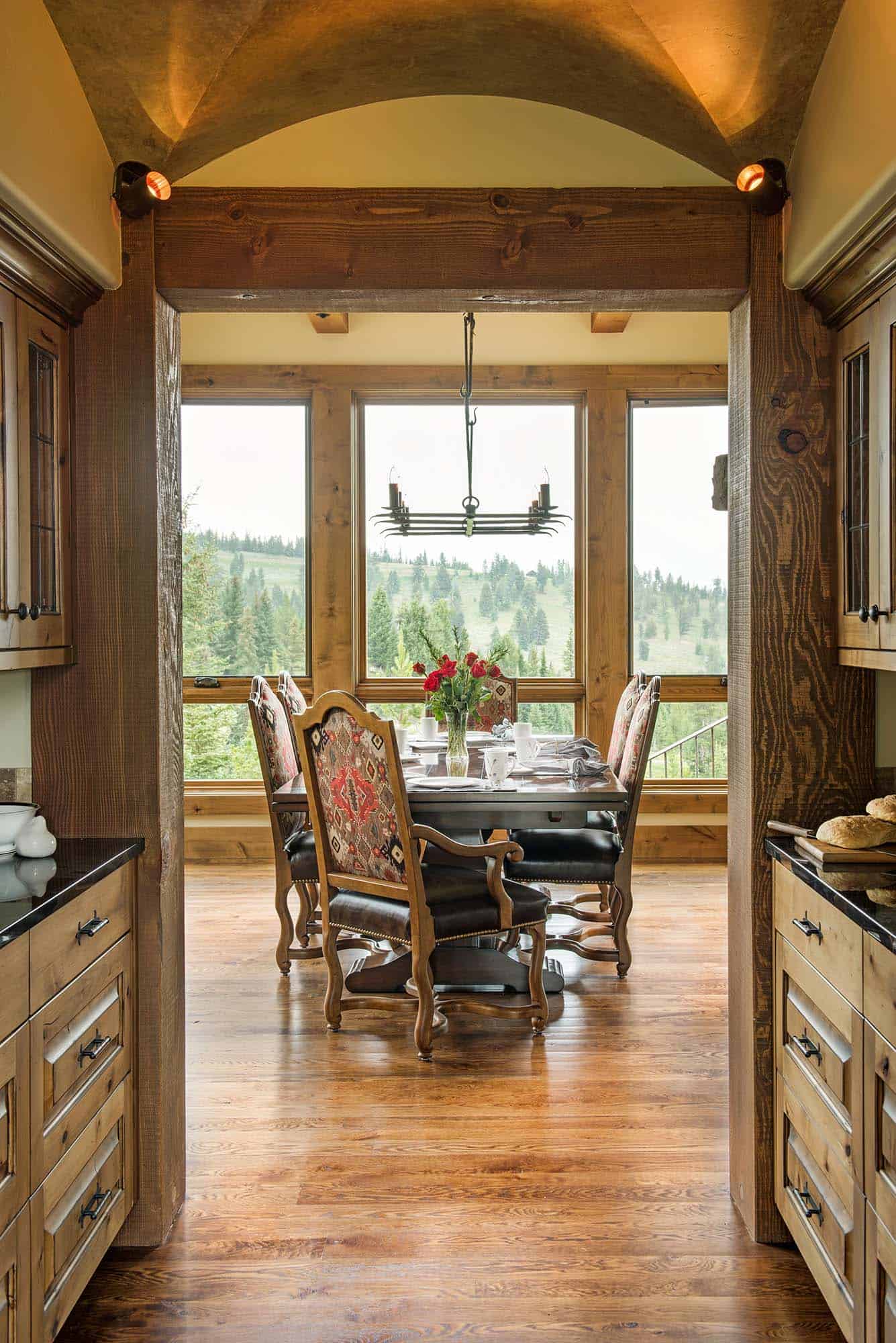 rustic dining room with a chandelier and large windows