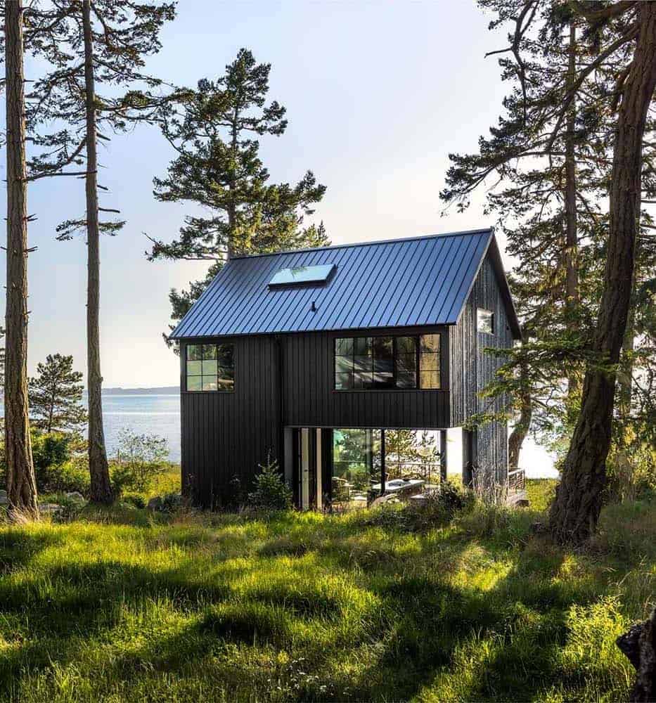 small black cabin exterior overlooking the water