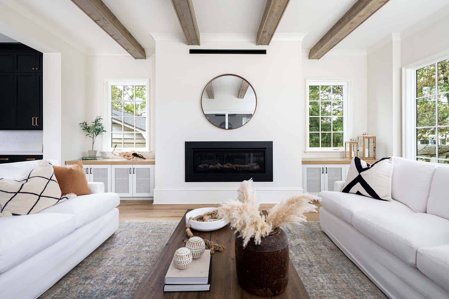 contemporary living room with wood ceiling beams and a fireplace 