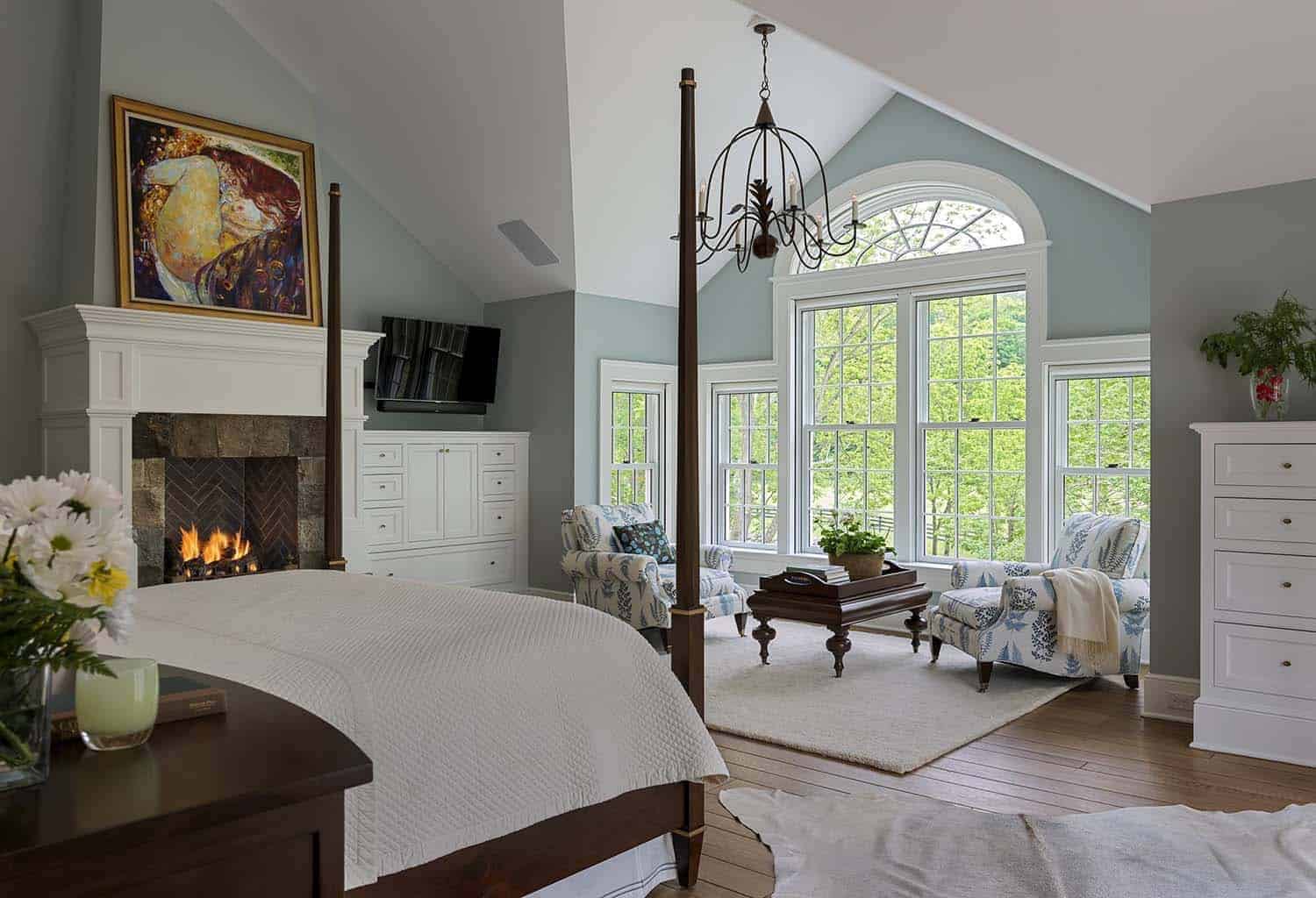 farmhouse style bedroom with large windows and a sitting area