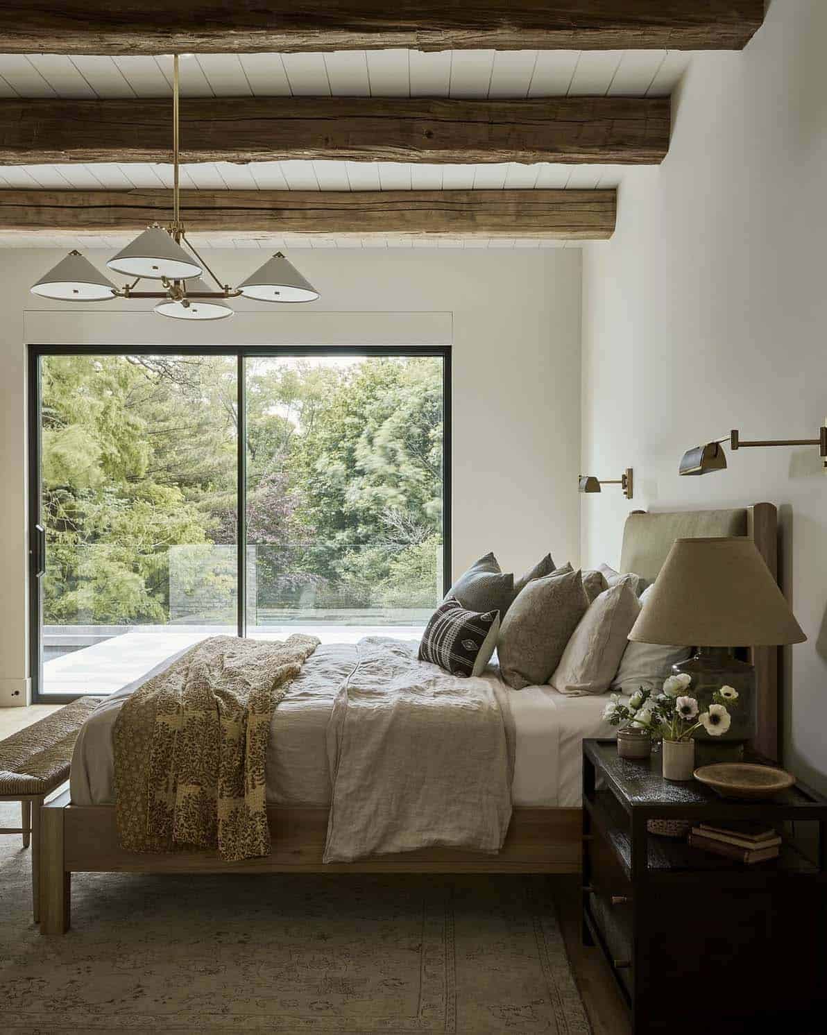 transitional style bedroom with wood beam ceiling and sliding glass doors