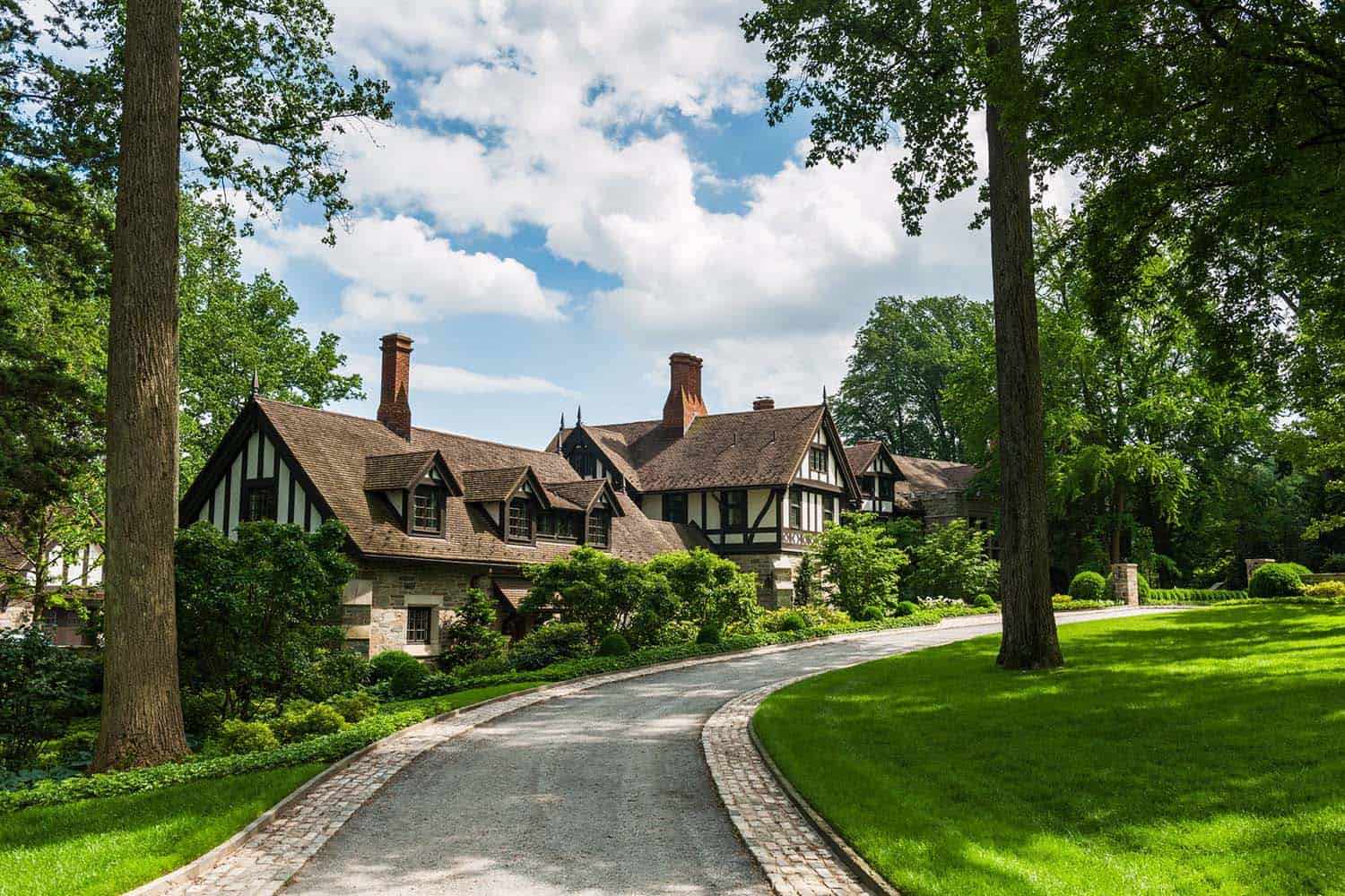 tudor style home exterior with a long driveway