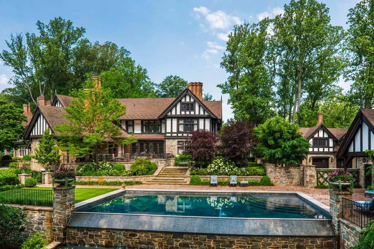 tudor style home exterior with a pool