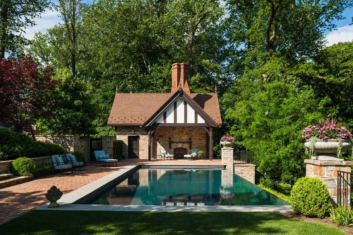 tudor style home exterior with a pool