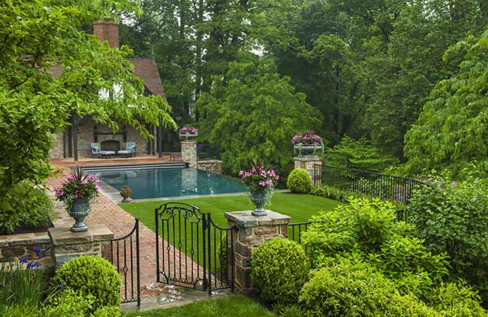 tudor style home exterior landscape with a pool