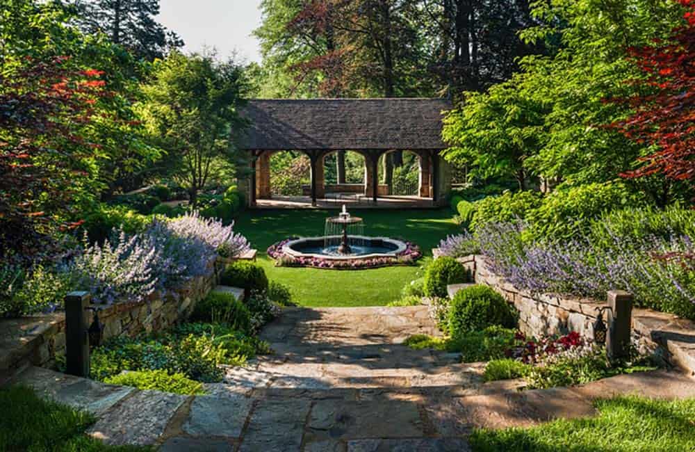 tudor style home exterior landscape with a water feature