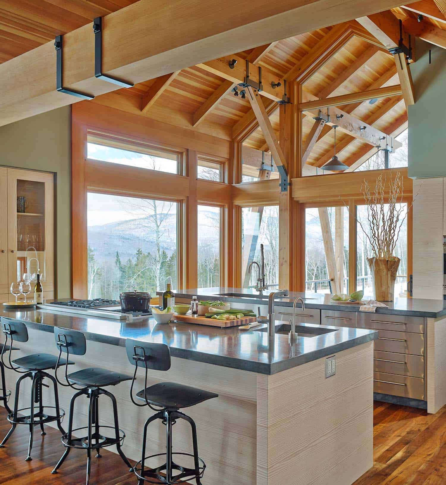 modern mountain style kitchen with wood ceiling trusses and large window view