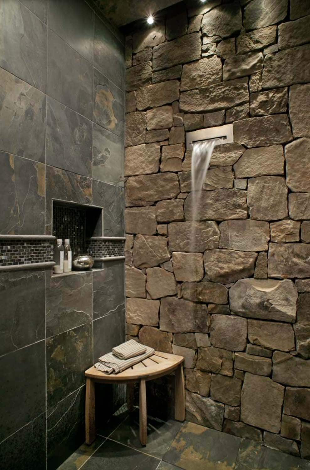 rustic stone shower with a waterfall shower head