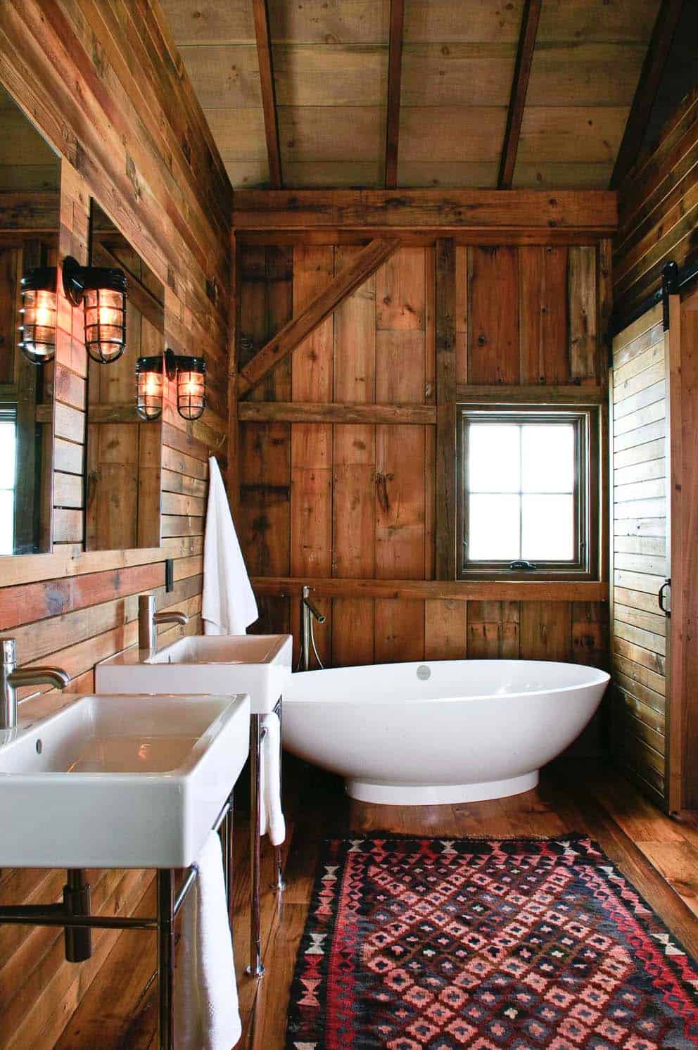 rustic barn bathroom with a freestanding tub and sliding barn door