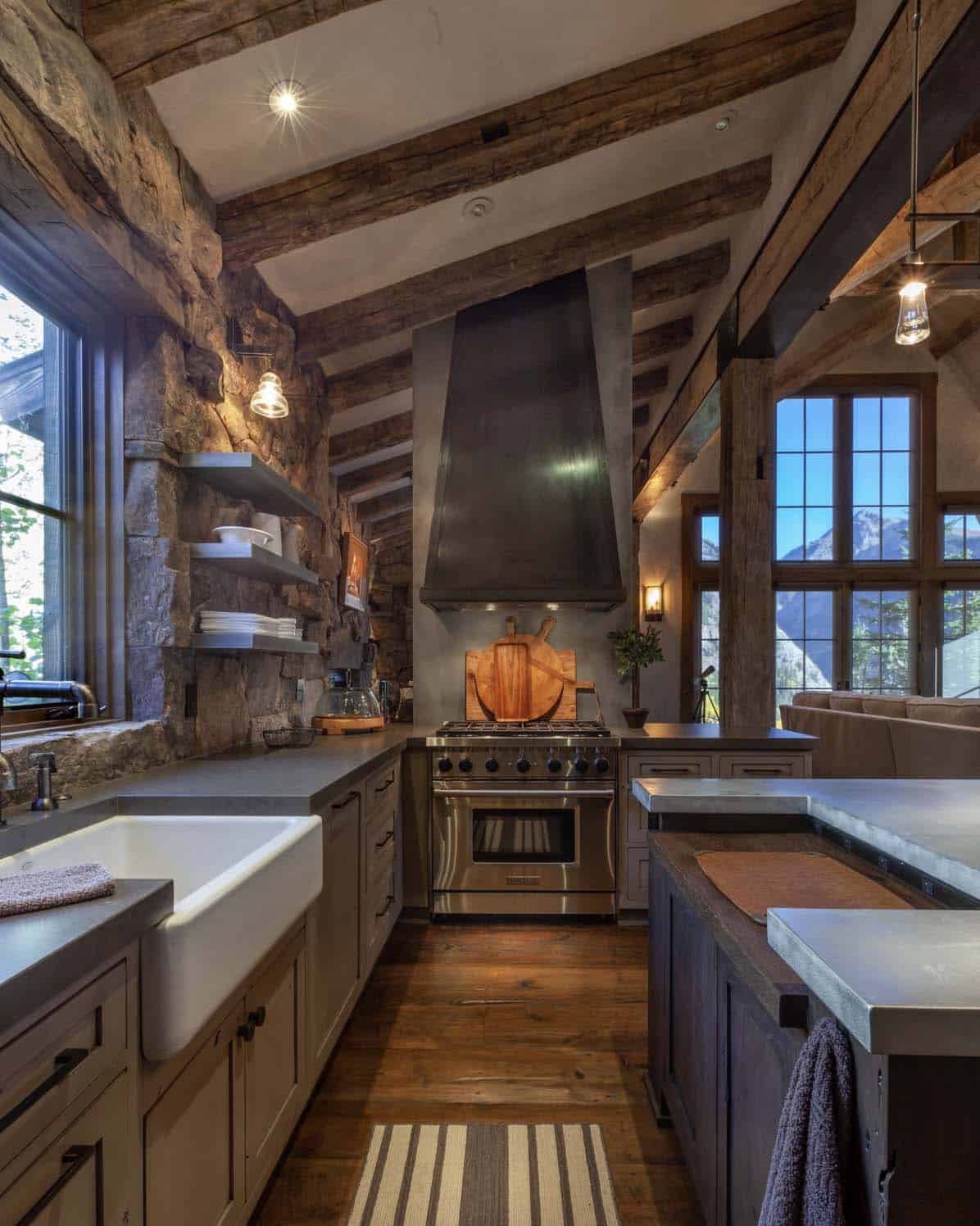 rustic kitchen with a large custom metal hood and farmhouse sink