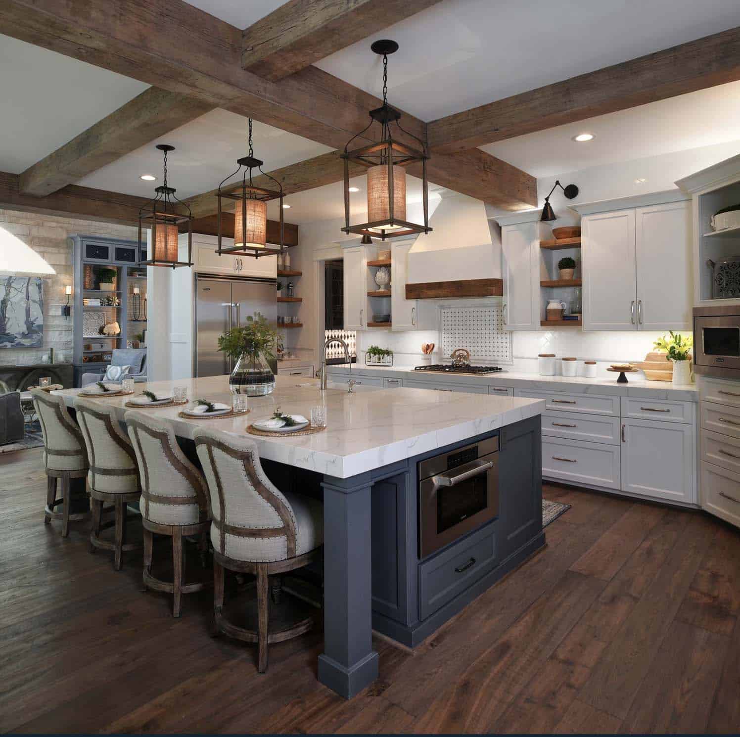 rustic kitchen with wood ceiling beams and a blue painted island with white perimeter cabinets