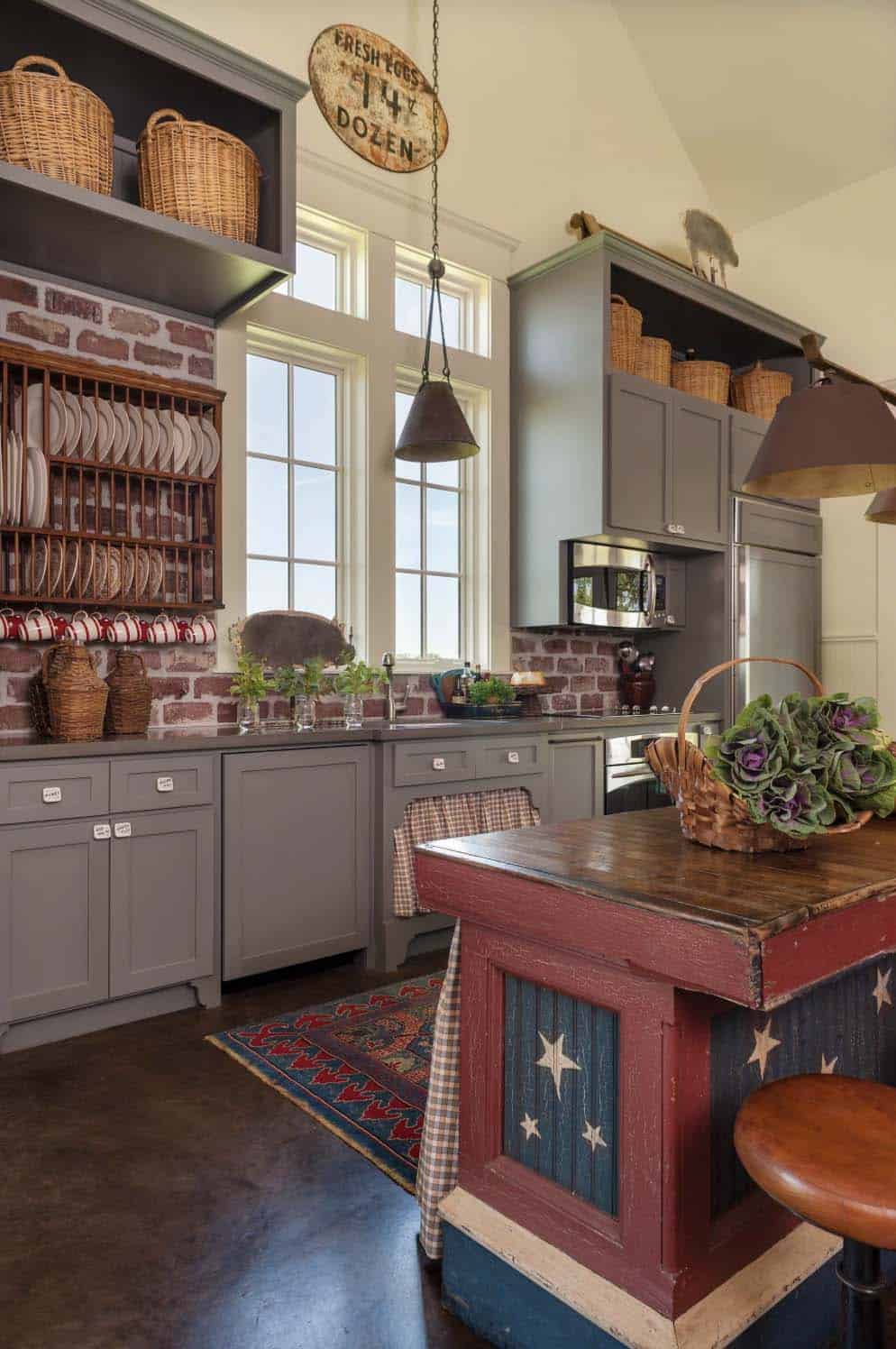 rustic farmhouse style kitchen with a red island and gray cabinets with a brick backsplash