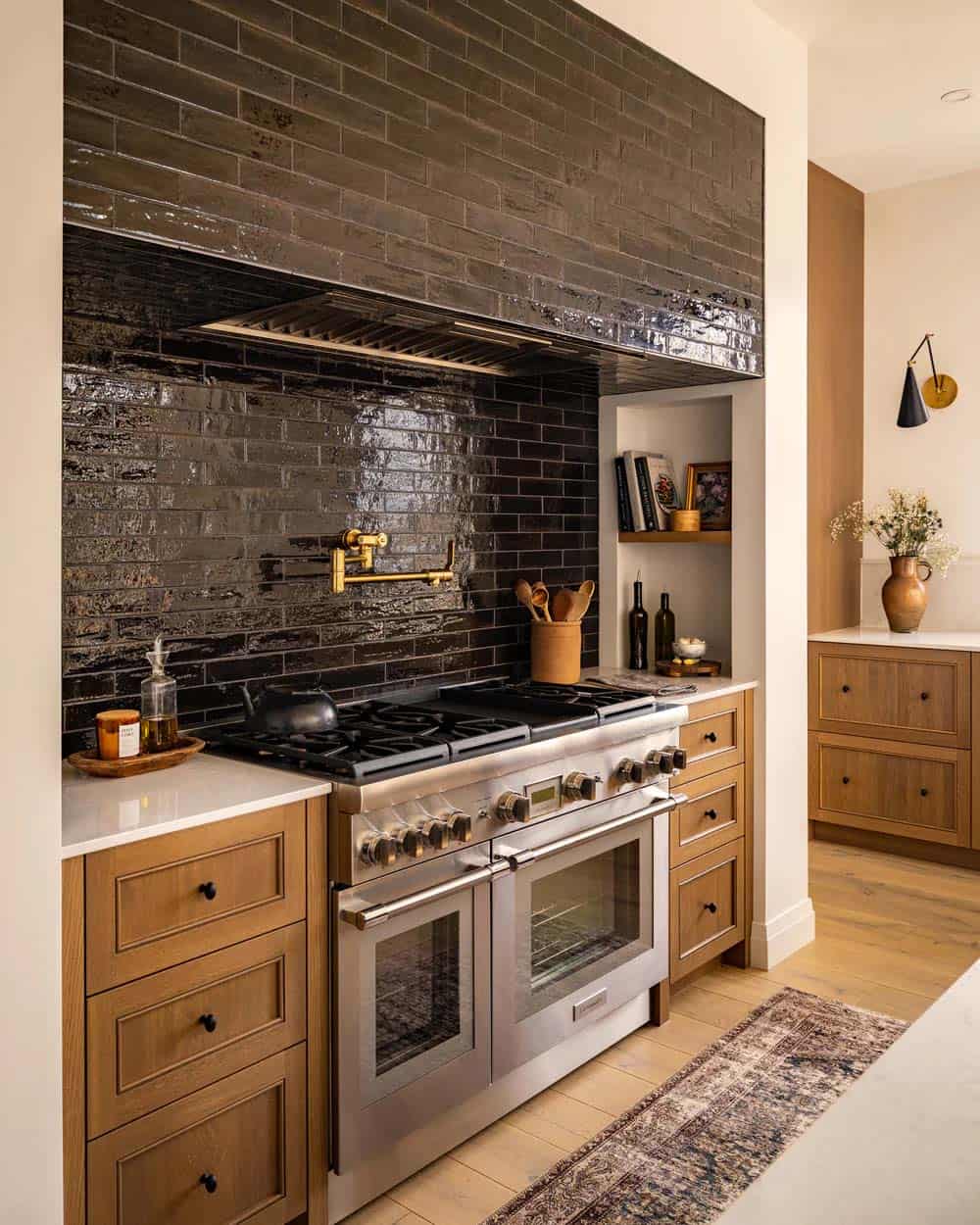 contemporary kitchen with black backsplash tile above the range