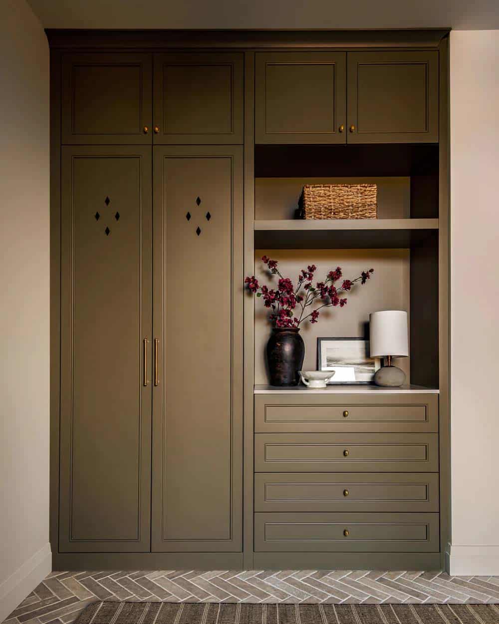 contemporary mudroom with a built-in storage closet painted in olive green and brick herringbone flooring