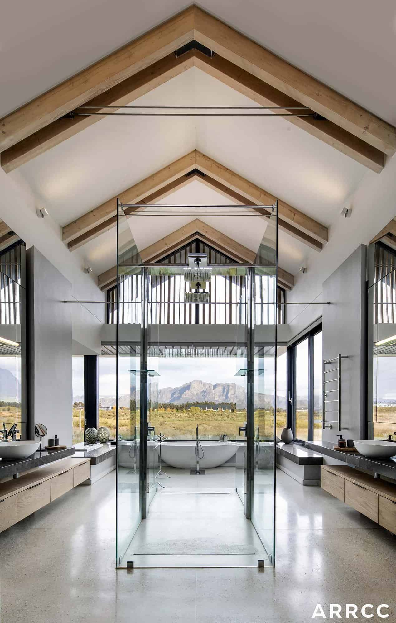 contemporary bathroom with a freestanding bath and large windows framing mountain views