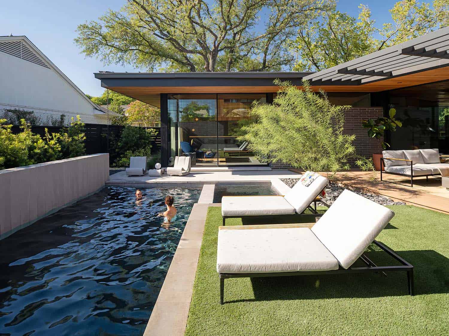 mid-century modern home exterior with a pool and chaise lounges