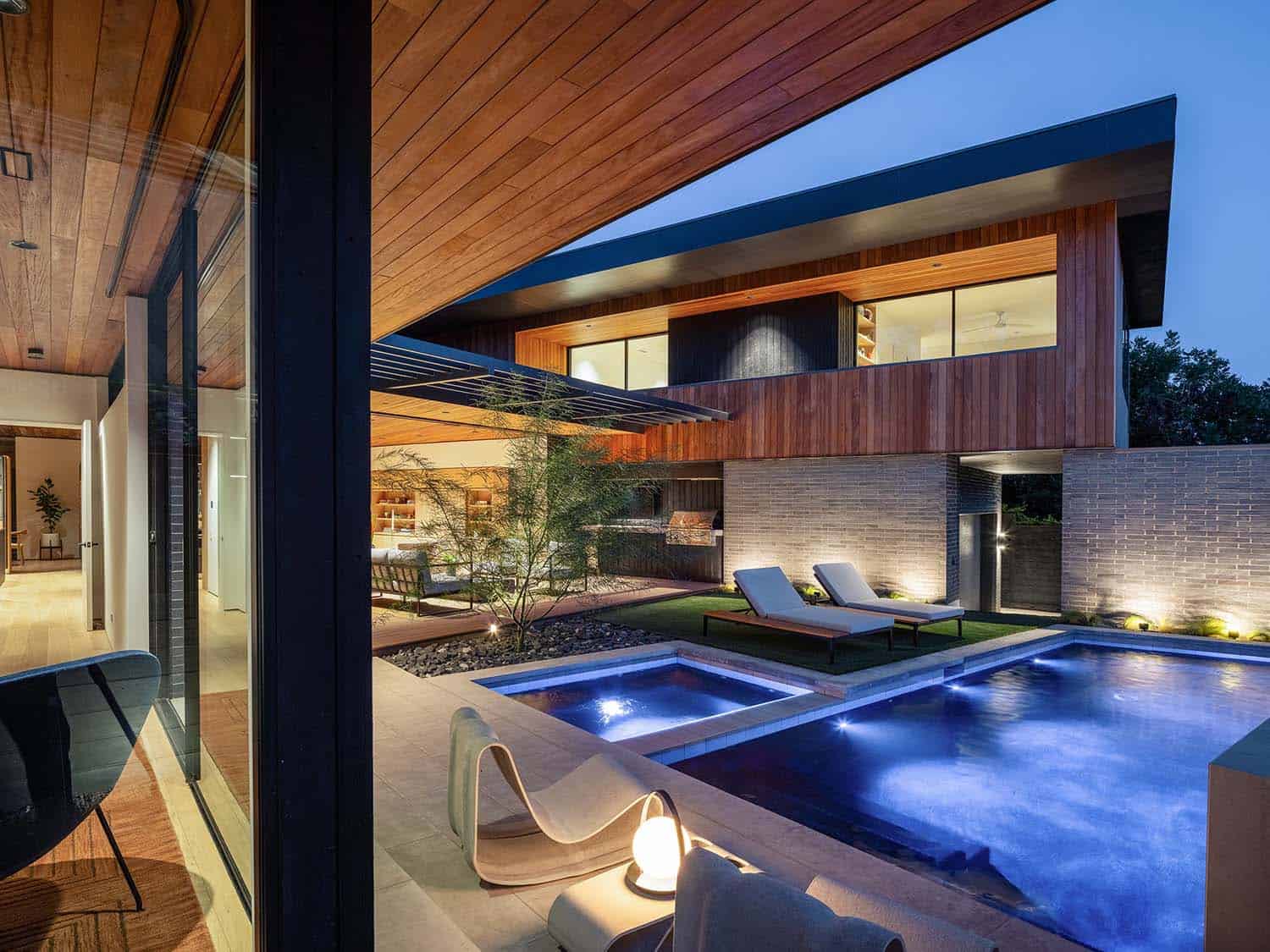 mid-century modern home exterior with a pool at dusk