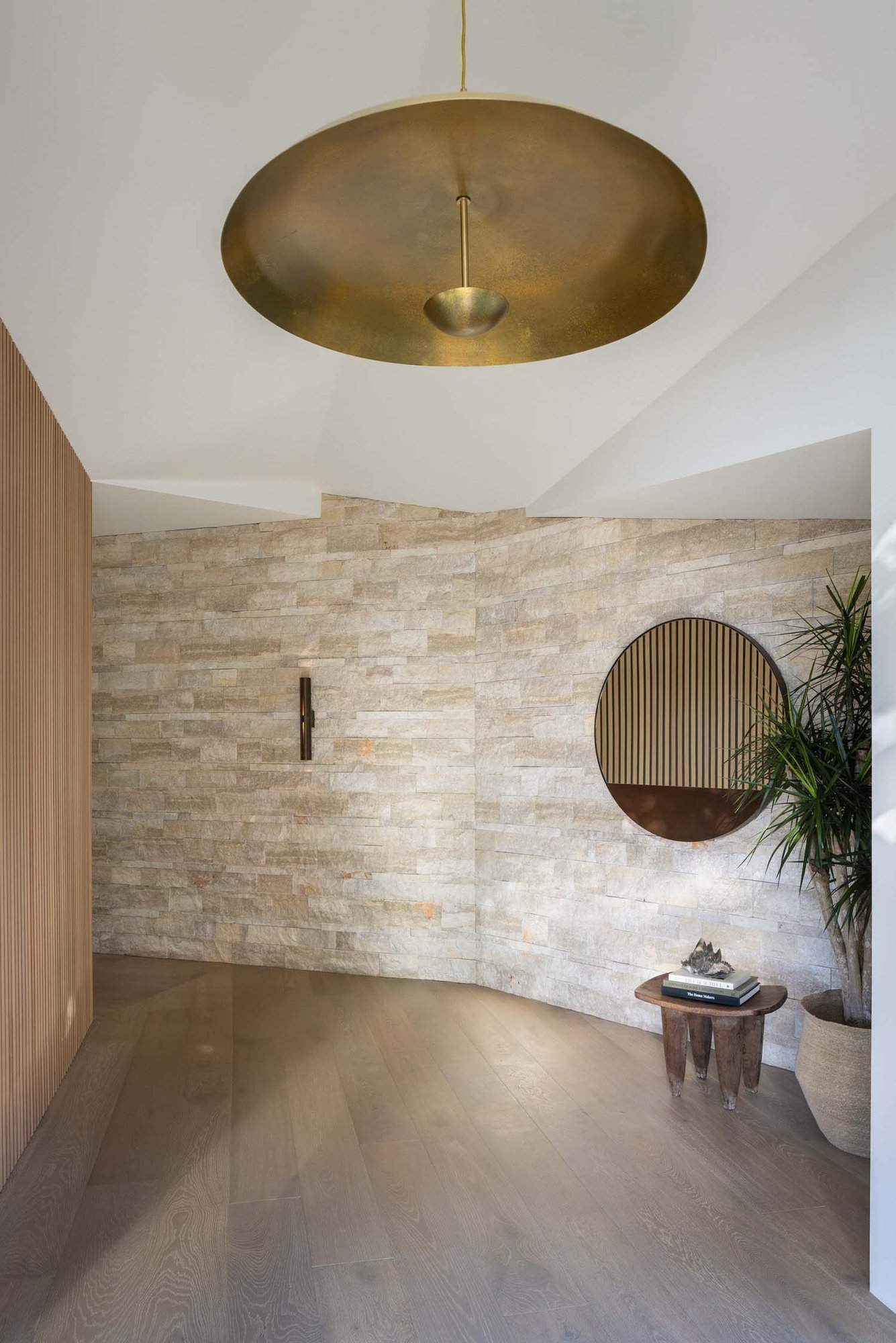 midcentury modern home entry with a curved stone wall