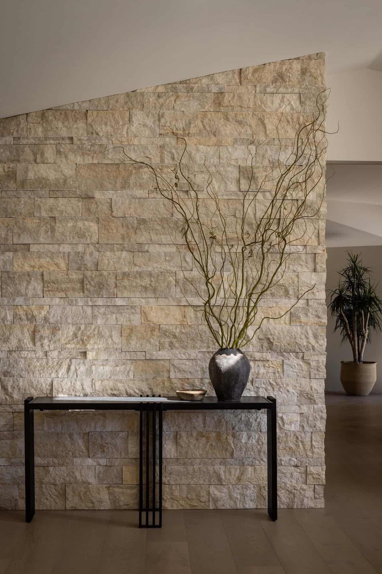 midcentury modern hallway with a stone wall and a console table