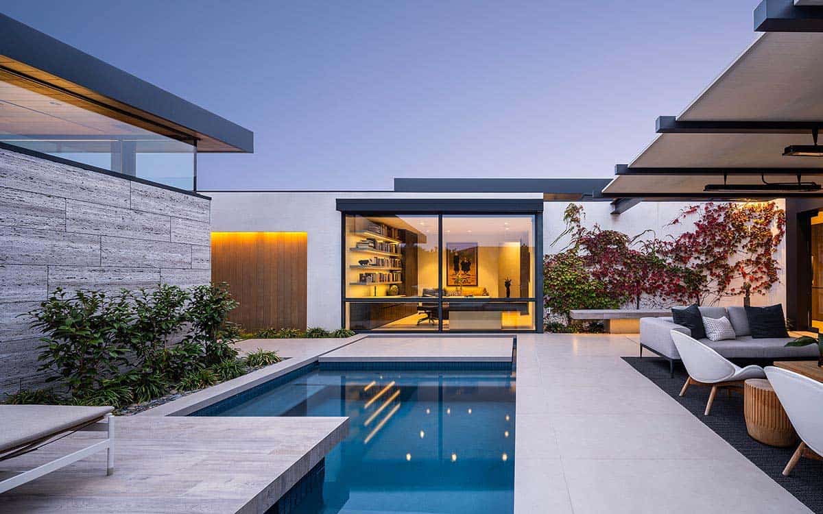 modern home exterior with a pool at dusk