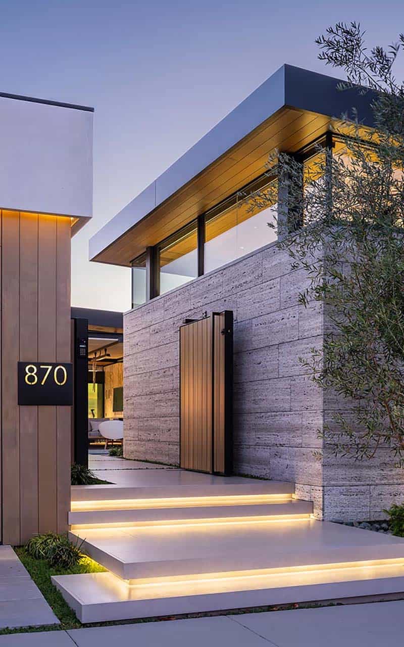 modern home exterior with an entry gate at dusk