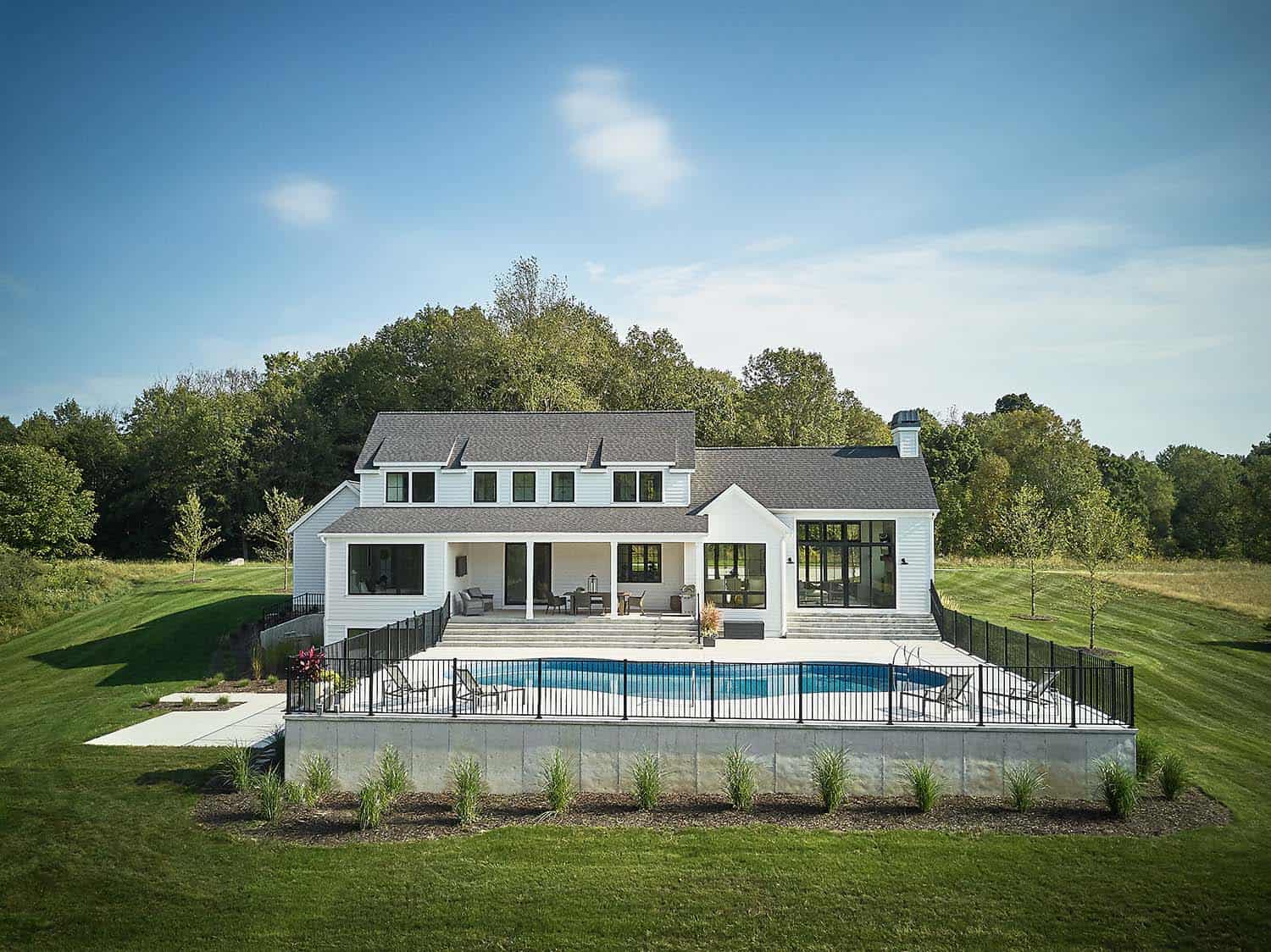 modern farmhouse home exterior backyard view with a pool