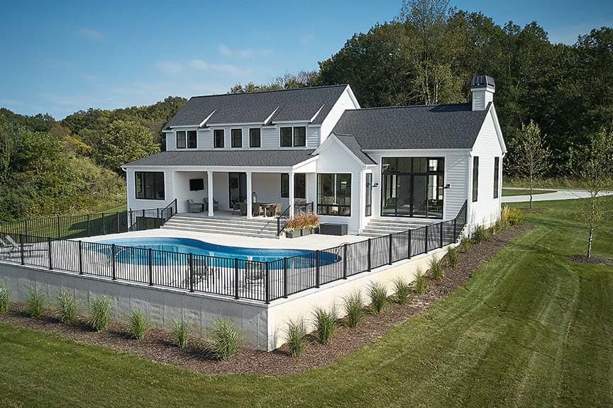modern farmhouse home exterior backyard view with a pool