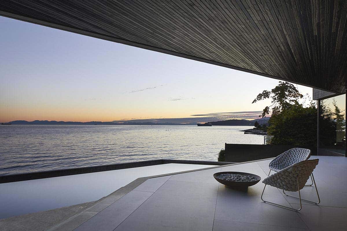 modern home patio with a view of the pool and ocean