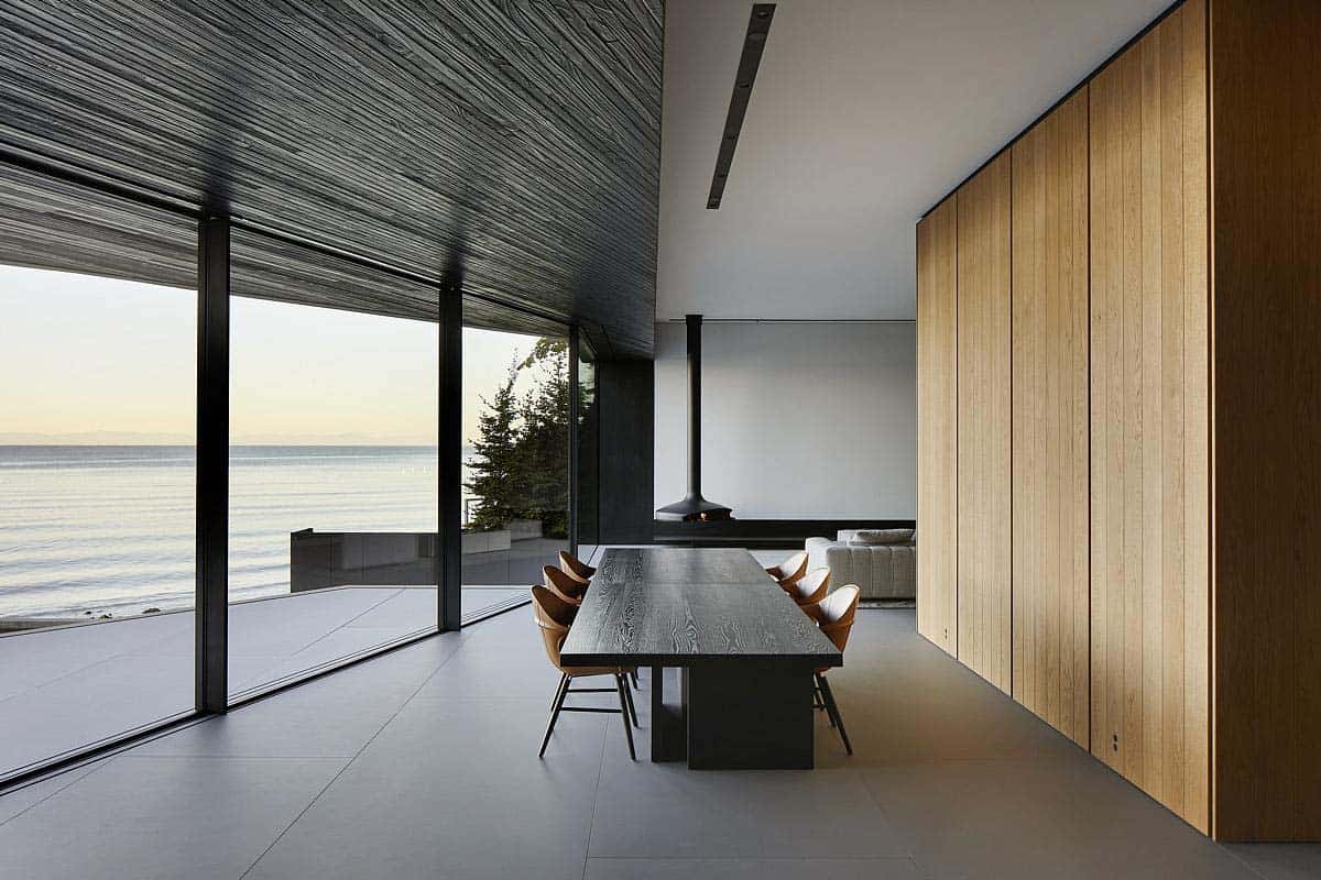 modern dining room with a glass wall and view of the ocean