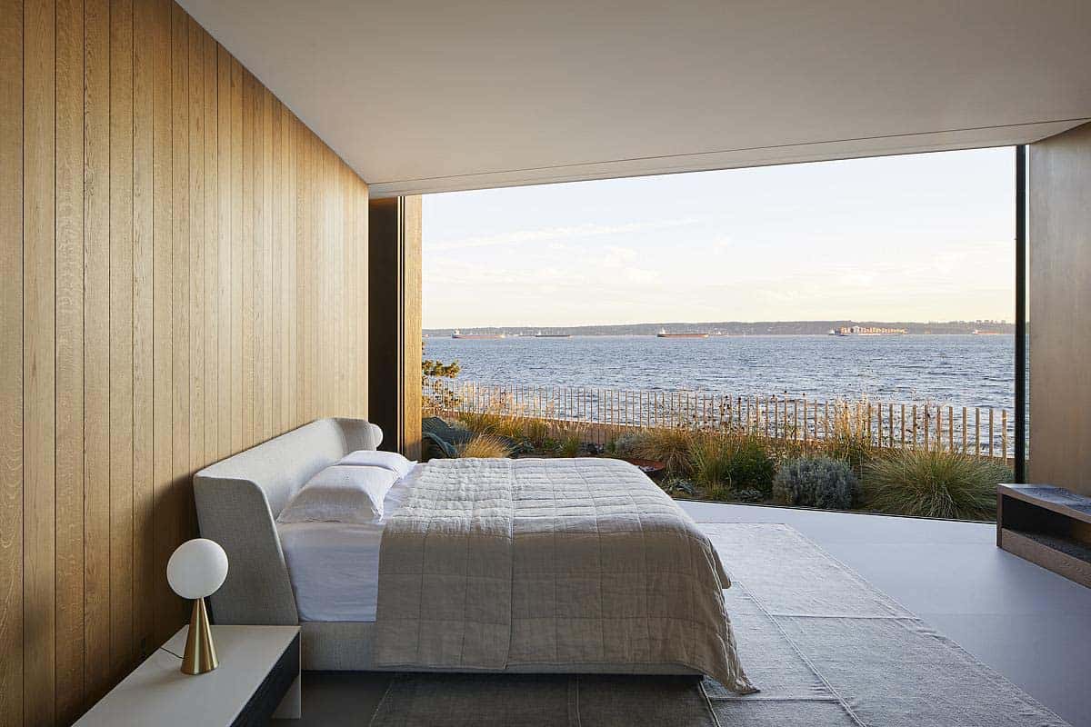 modern bedroom with a wall of glass and a view to the ocean