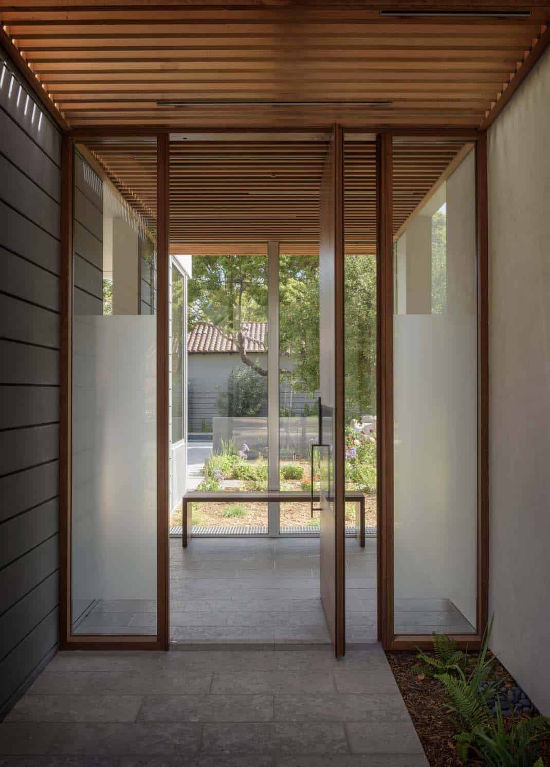 modern home entry with a pivoting glass door