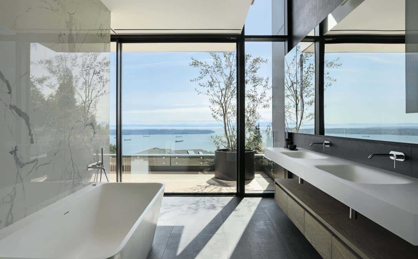 modern bathroom with a vanity and freestanding tub and wall of glass with an ocean view