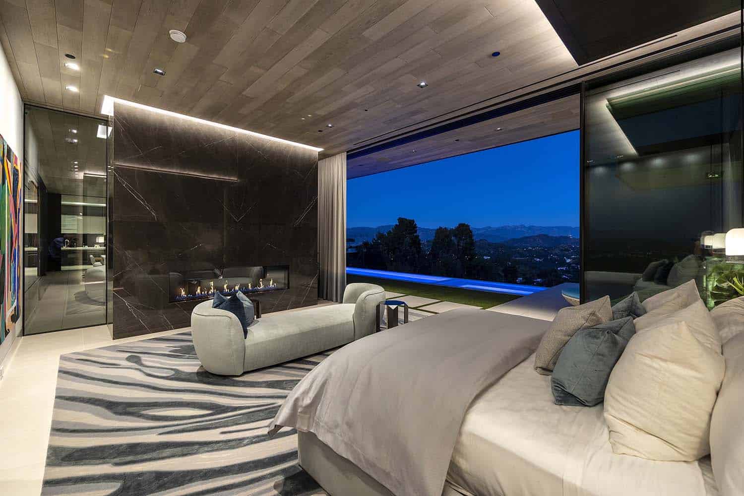 modern bedroom with a fireplace and sliding glass door with a view