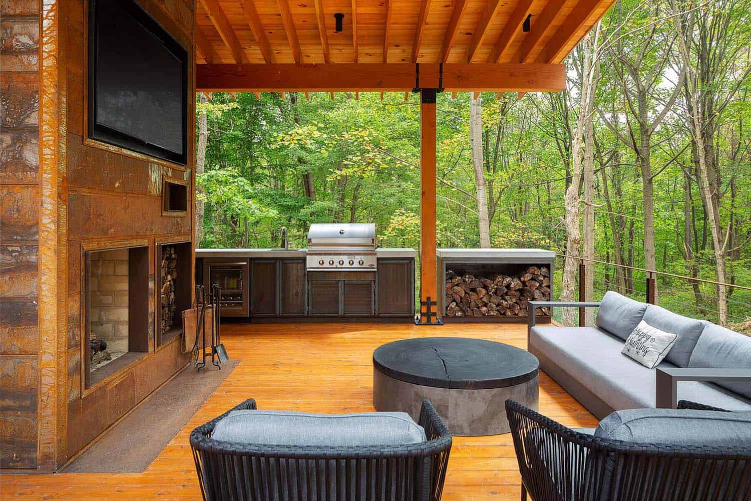 rustic deck with a fireplace and a grill