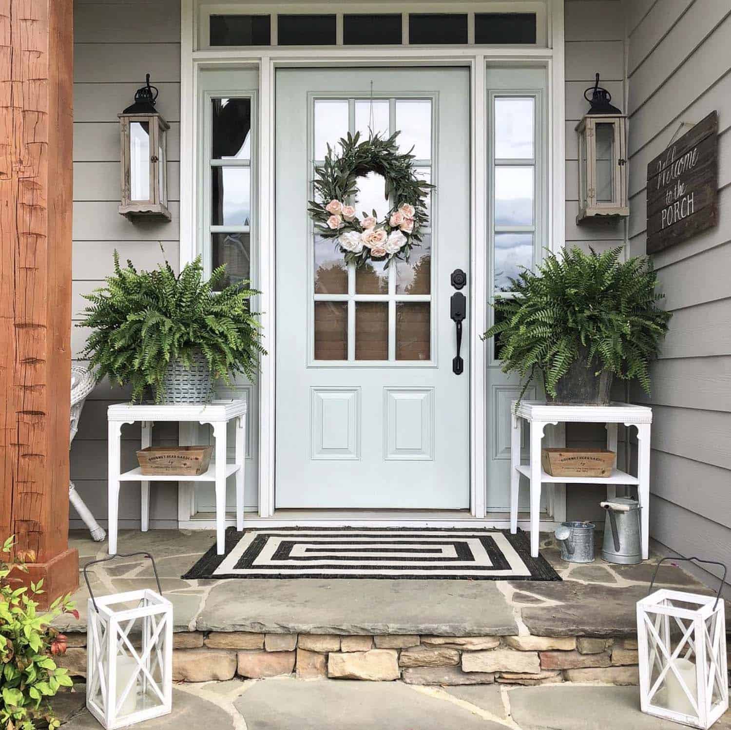 front porch with a spring wreath, plants and lanterns