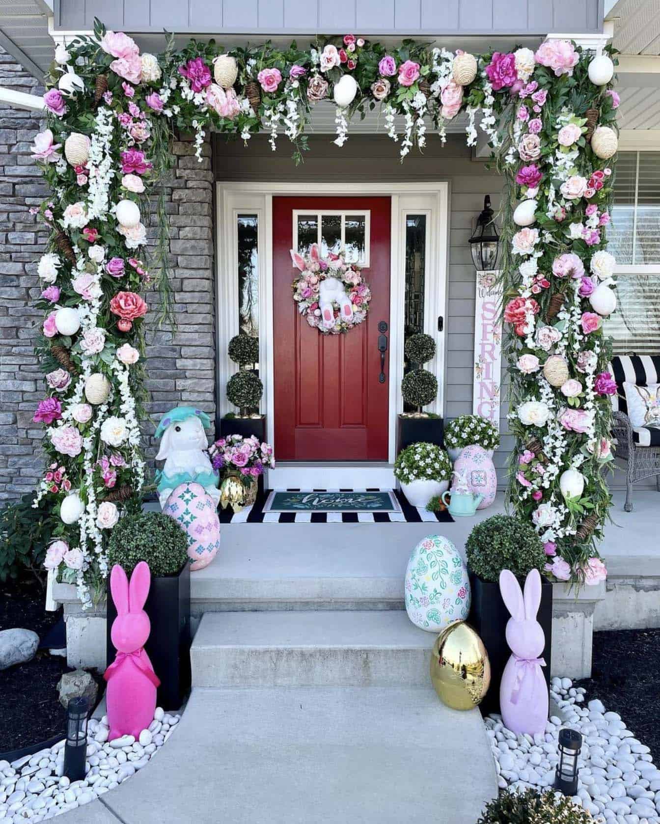 front porch decorated for spring with garland, bunnies and eggs