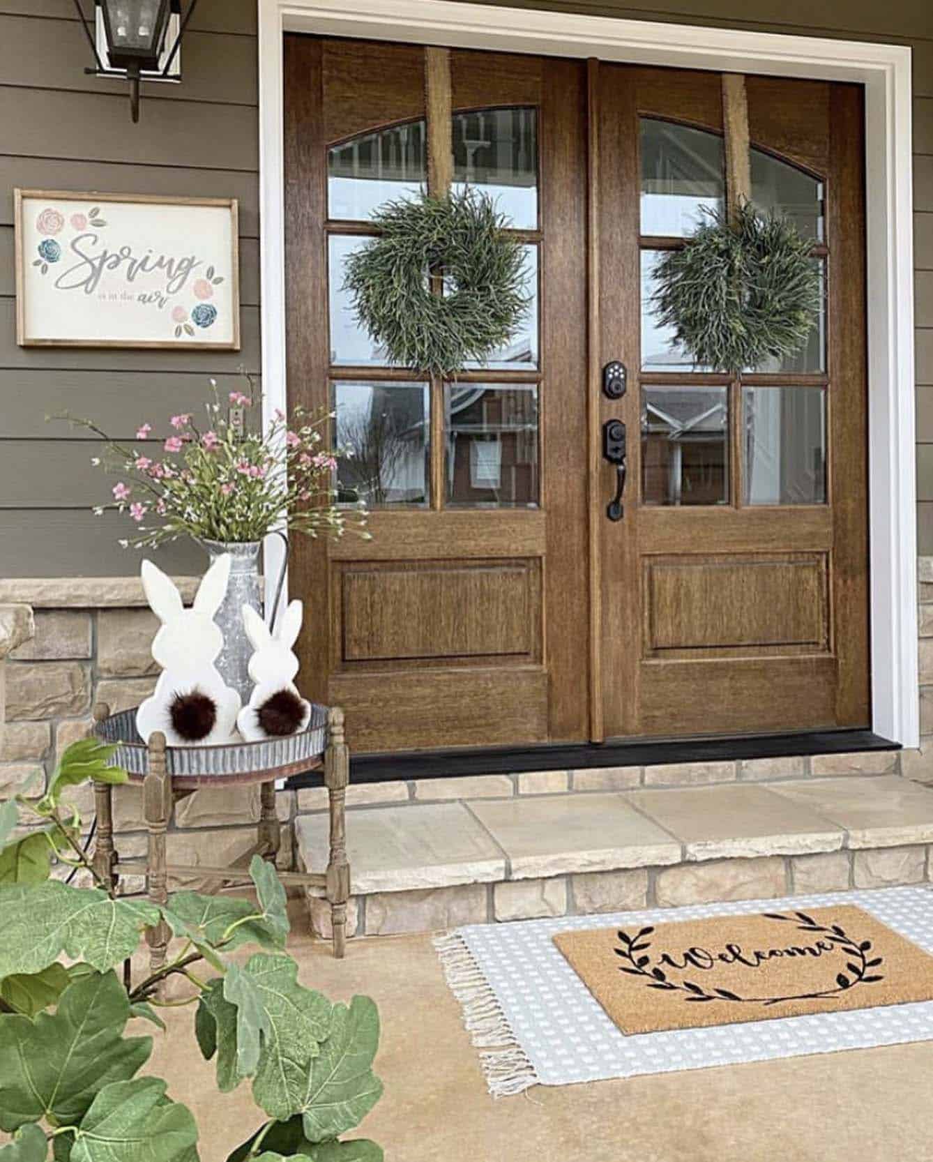front porch with two door wreaths, bunnies and wooded spring signs