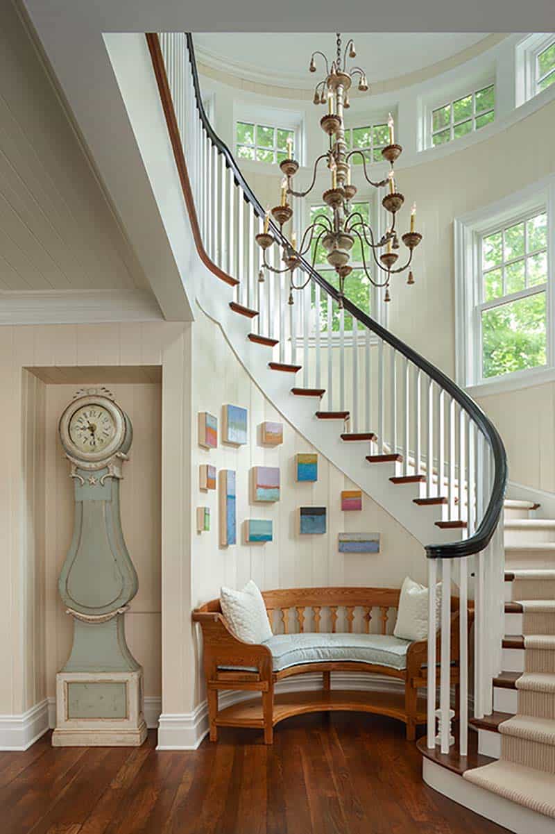 traditional coastal style curved staircase with a Swedish mora clock