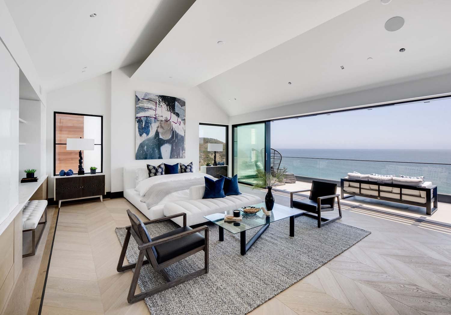 coastal contemporary bedroom with a sliding glass door that opens to the ocean