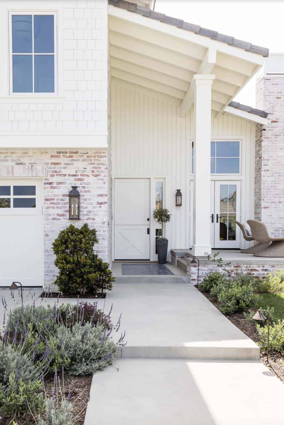 coastal home exterior with a Dutch door and white-washed brick