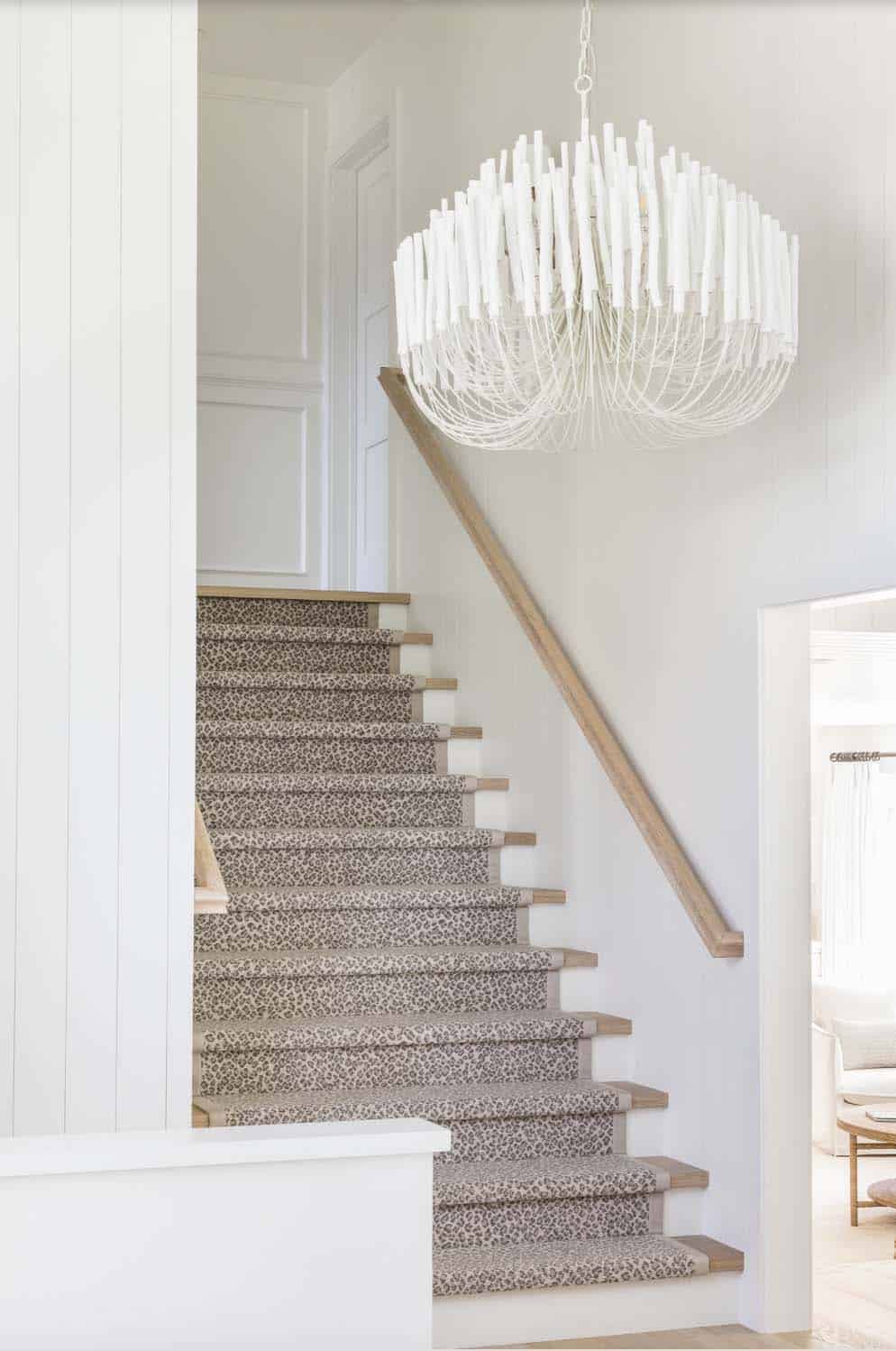 coastal home entry with a staircase and large chandelier