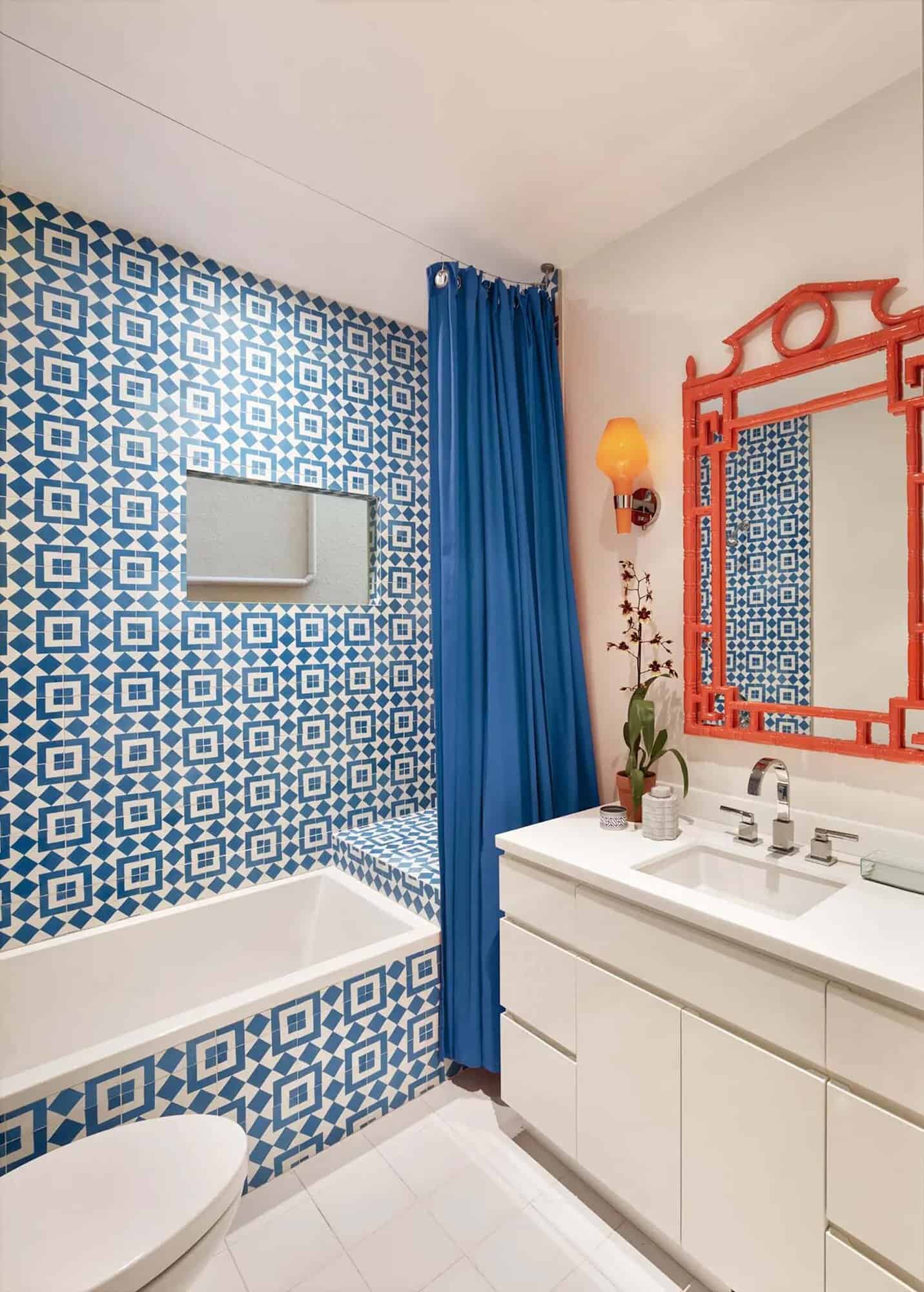 contemporary bathroom with a vanity and shower tub combo with blue and white tile