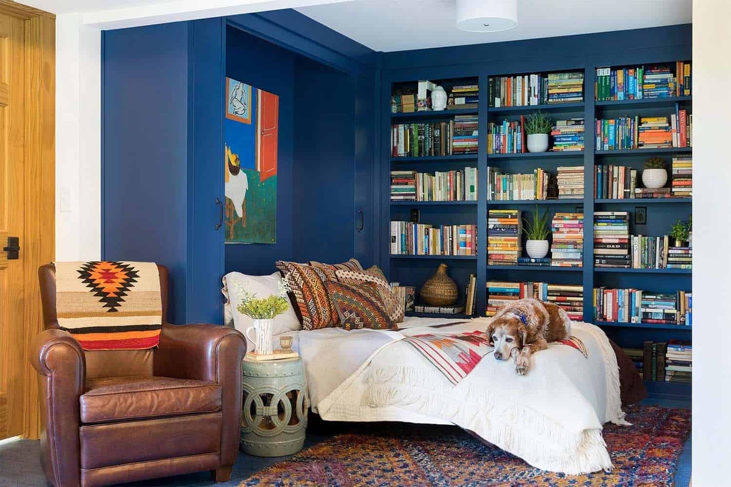 guest bedroom with a Murphy bed and custom built-in book shelves painted blue
