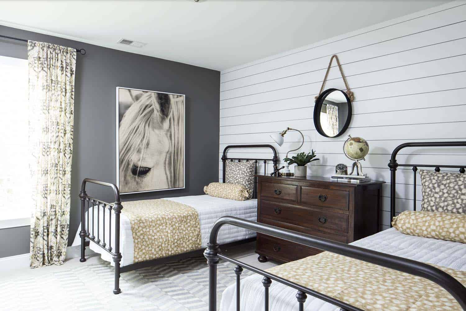 farmhouse style bedroom with shiplap walls and iron frame beds