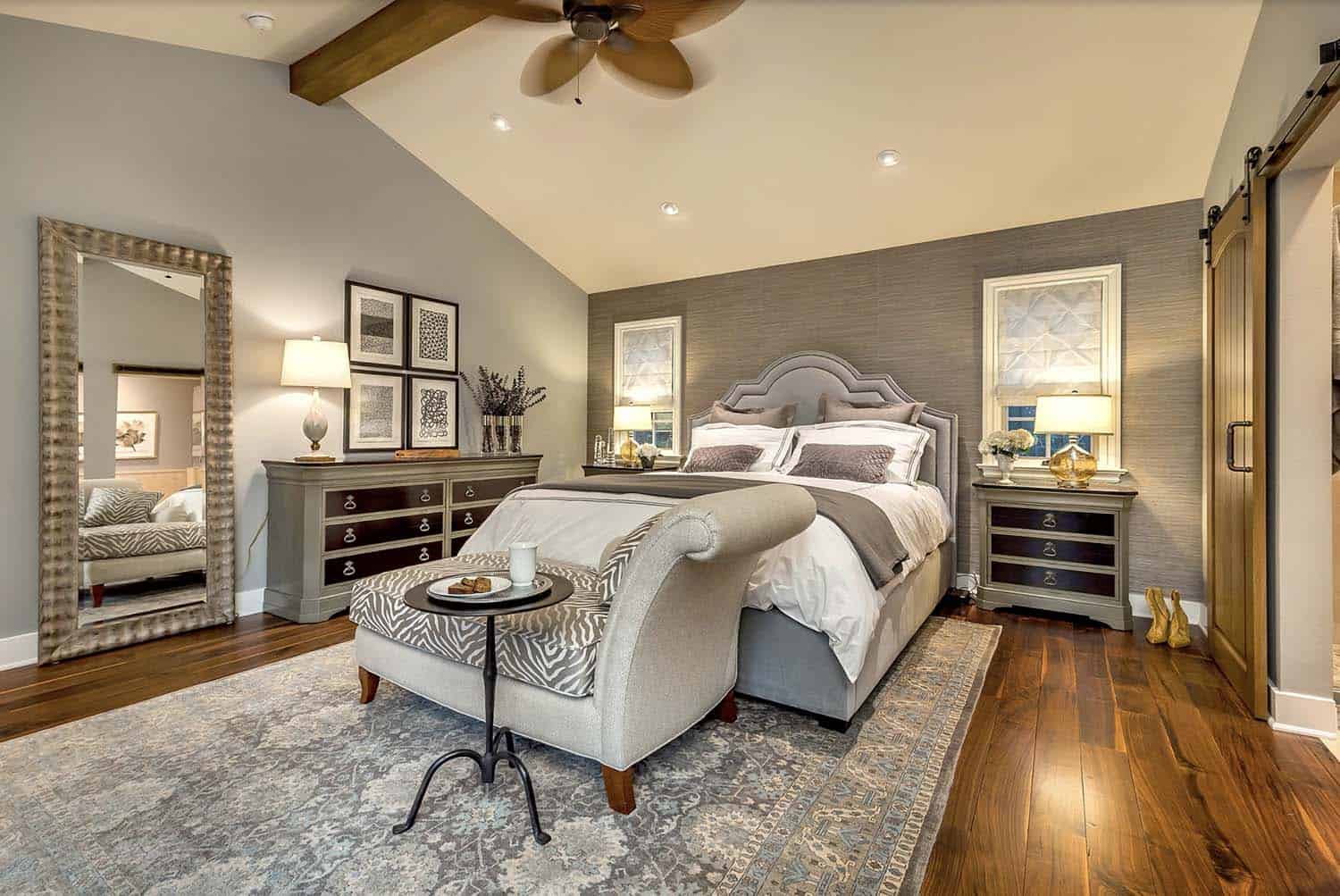 transitional style bedroom with a chaise lounge and gray painted walls
