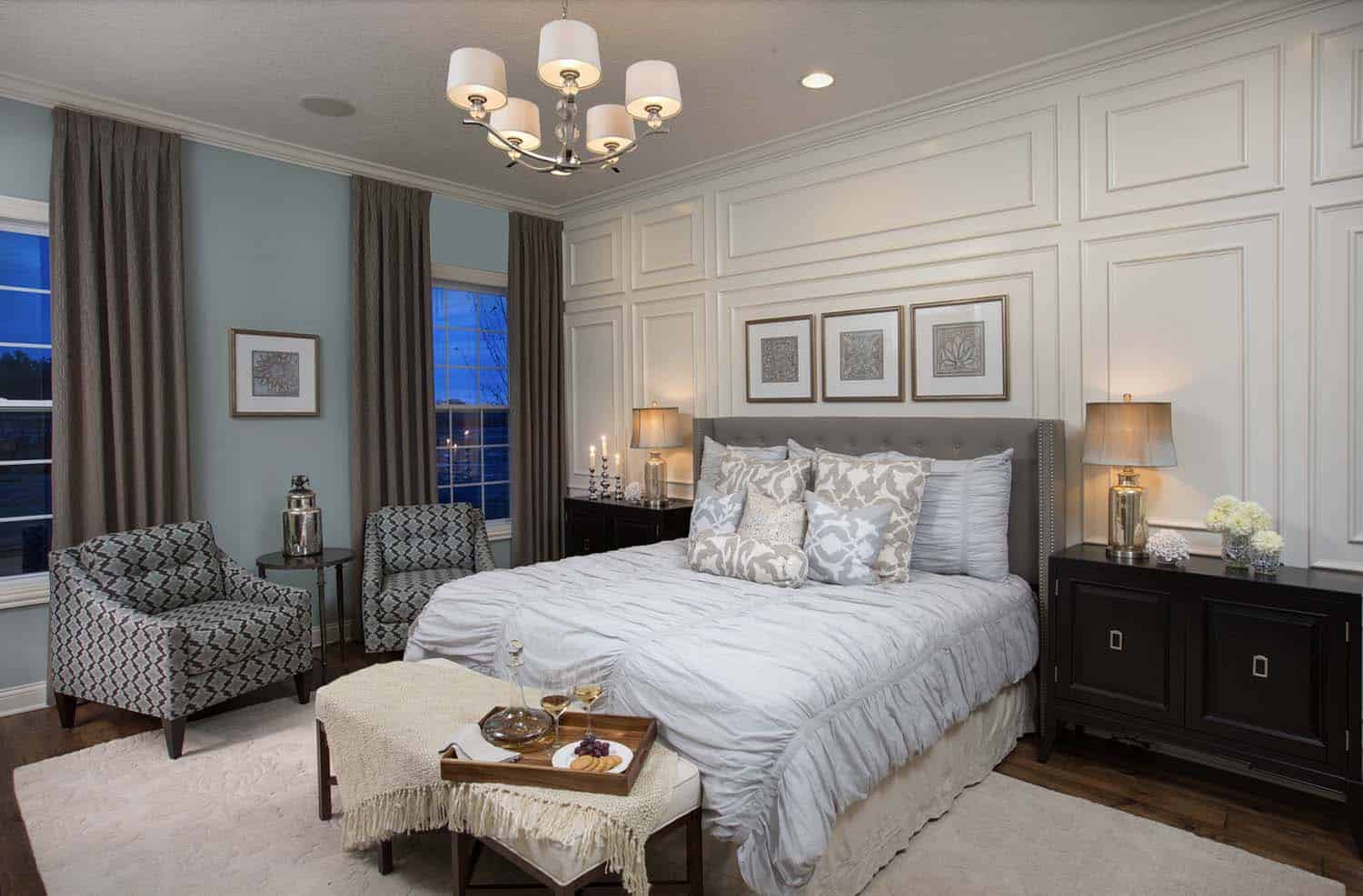 transitional style bedroom with an applied molding accent wall behind the bed